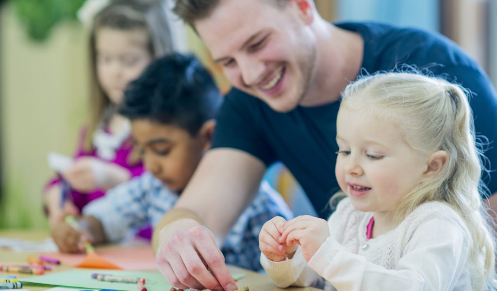 young male teaching young children